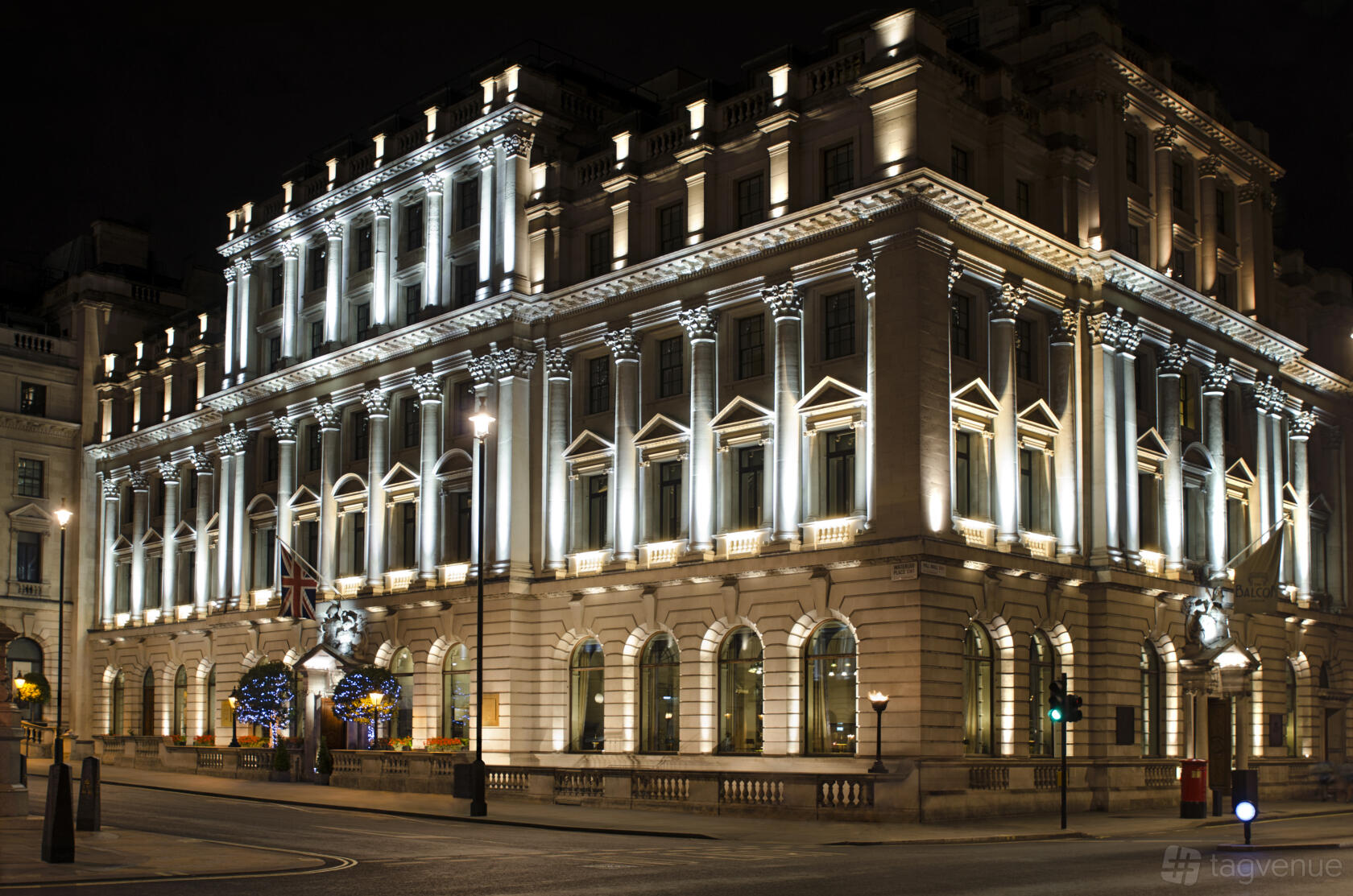 A grand neoclassical building with illuminated columns and arched windows at Meetings & Events Venues.