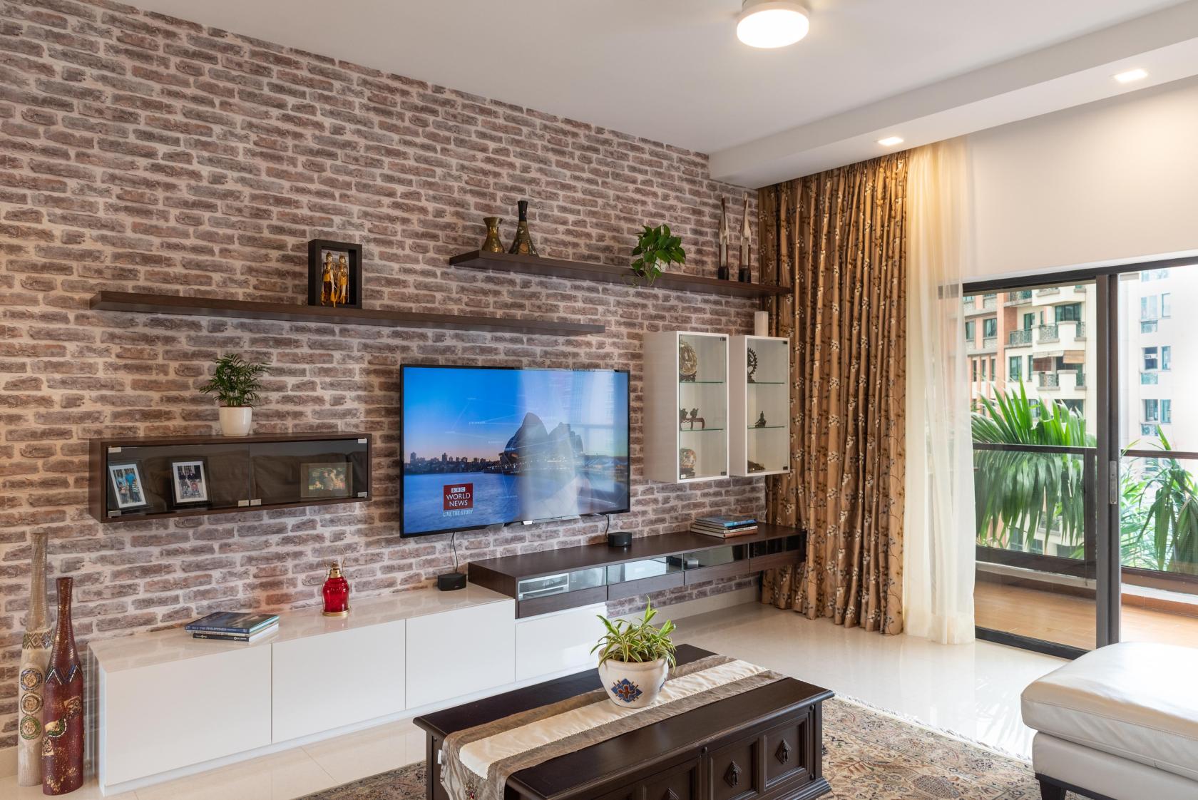 A spacious apartment living area with exposed brick accent wall, floating shelves, and large window at Bright Home.