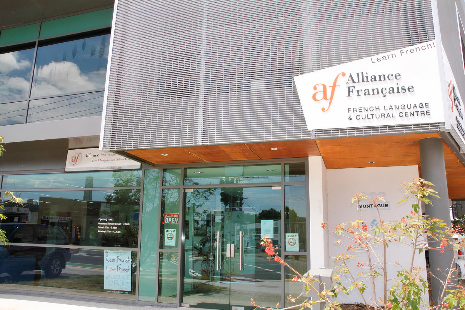 A meeting centre with glass entry doors, metal facade, and signage at Alliance Francaise de Brisbane.