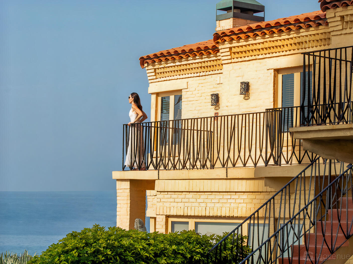 A hotel with a wrought-iron balcony overlooking the ocean at Pantai Inn.