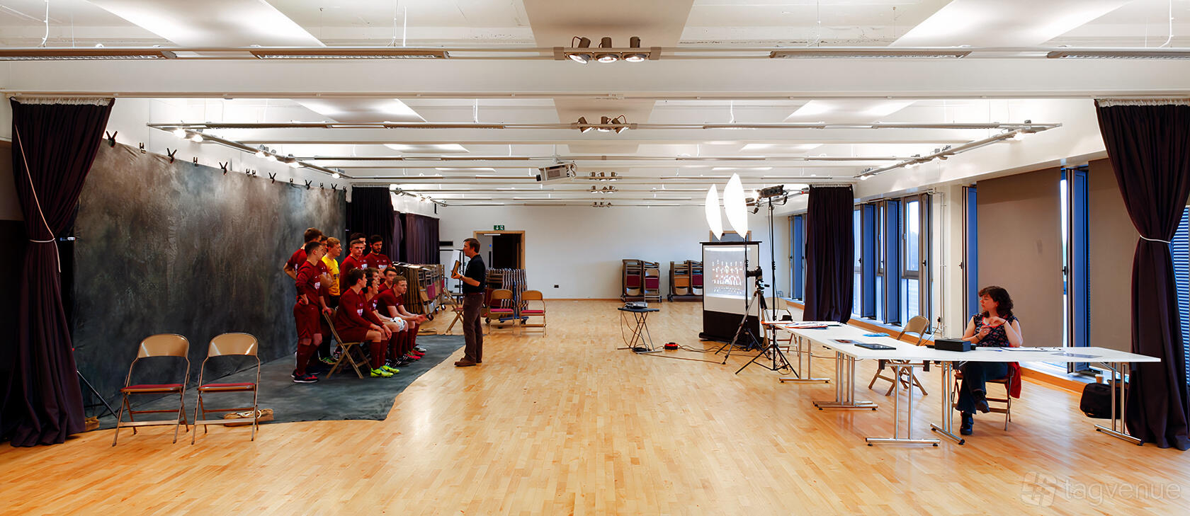 A rehearsal room with wood flooring, large windows, and portable lighting setup at University of Bristol Students' Union.