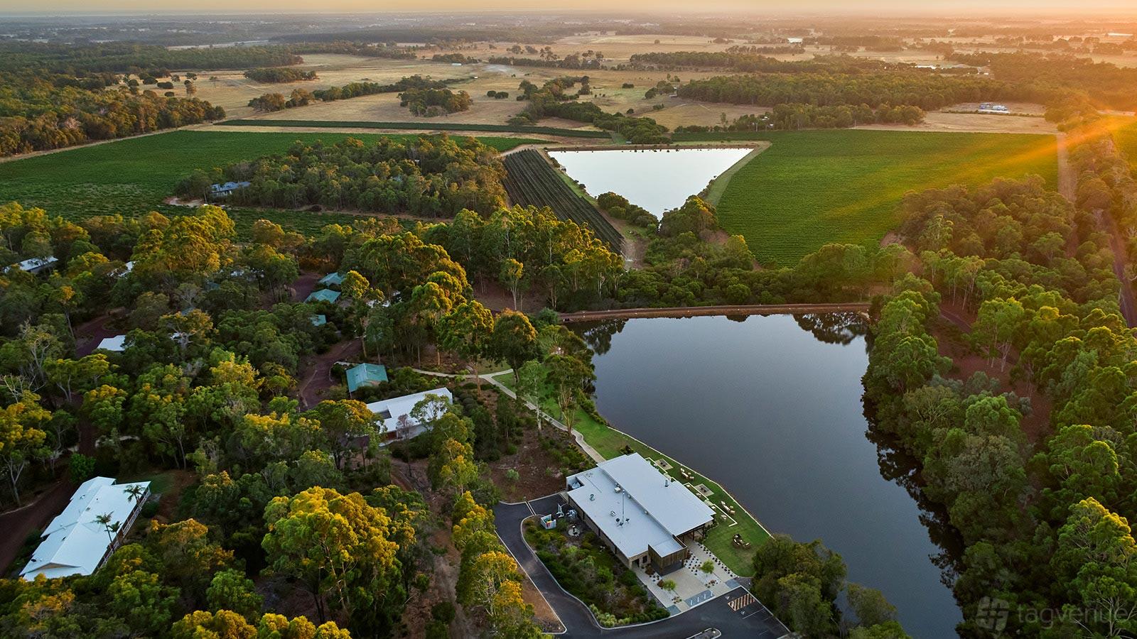 A hotel surrounded by dense trees, large ponds, and open fields at Eight Willows Retreat.