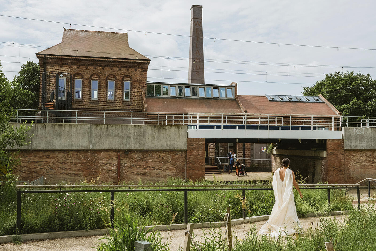 A blank canvas venue with historic brick buildings, tall windows, and lush greenery at Walthamstow Wetlands.