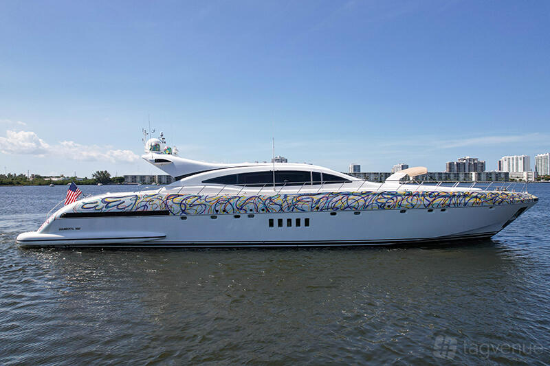 A white luxury yacht with colorful graphic accents docked on the water at Jerico Yacht Charters.