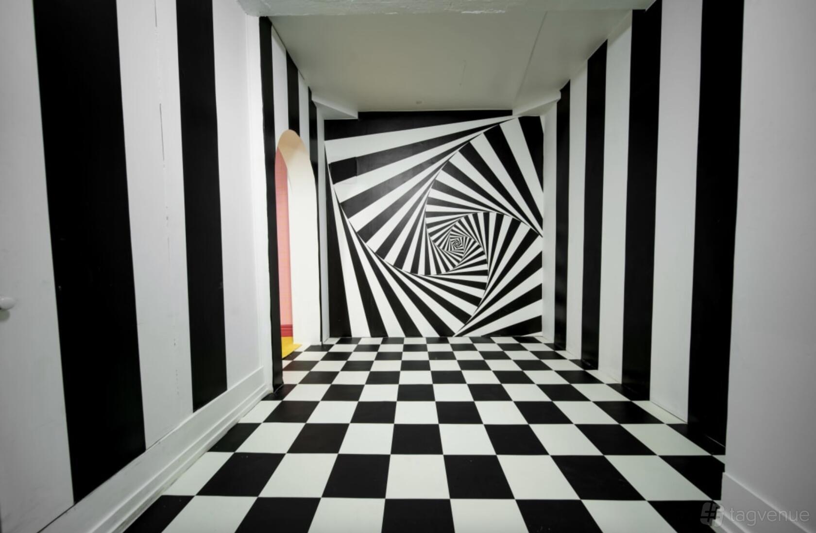 A photo studio with black and white checkered flooring and optical illusion spiral walls at Gunn Studio.