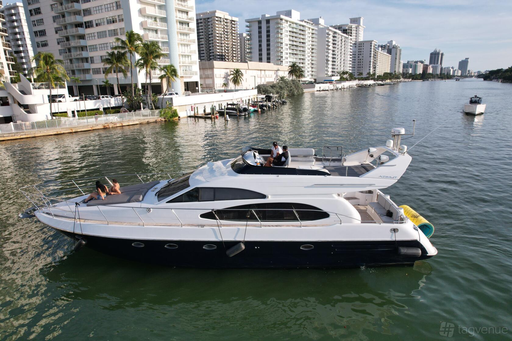 A large party yacht with upper and lower decks, lounge seating, and waterfront city views at Cangri Miami Yacht Rentals.