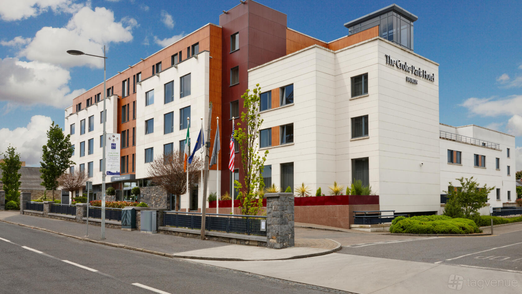 A meeting centre with a modern facade, large windows, and flagpoles at The Croke Park Hotel.