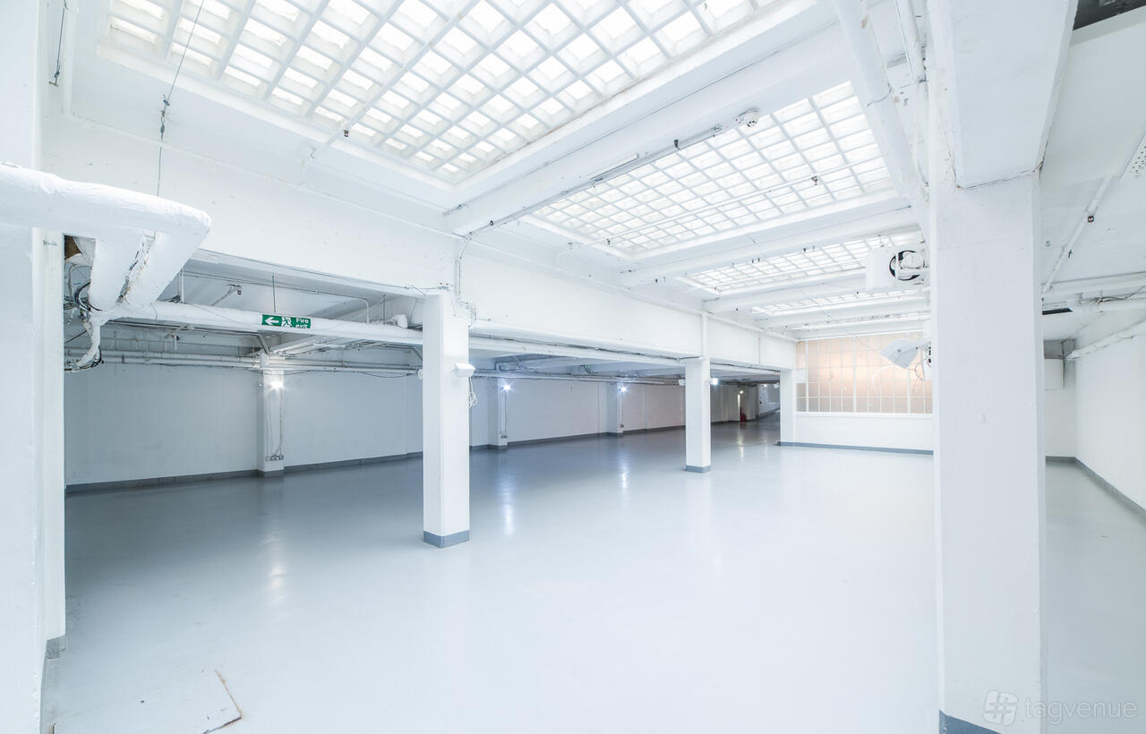 An event venue with high ceilings, white pillars, and glass panel lighting at The Vinyl Factory Soho.