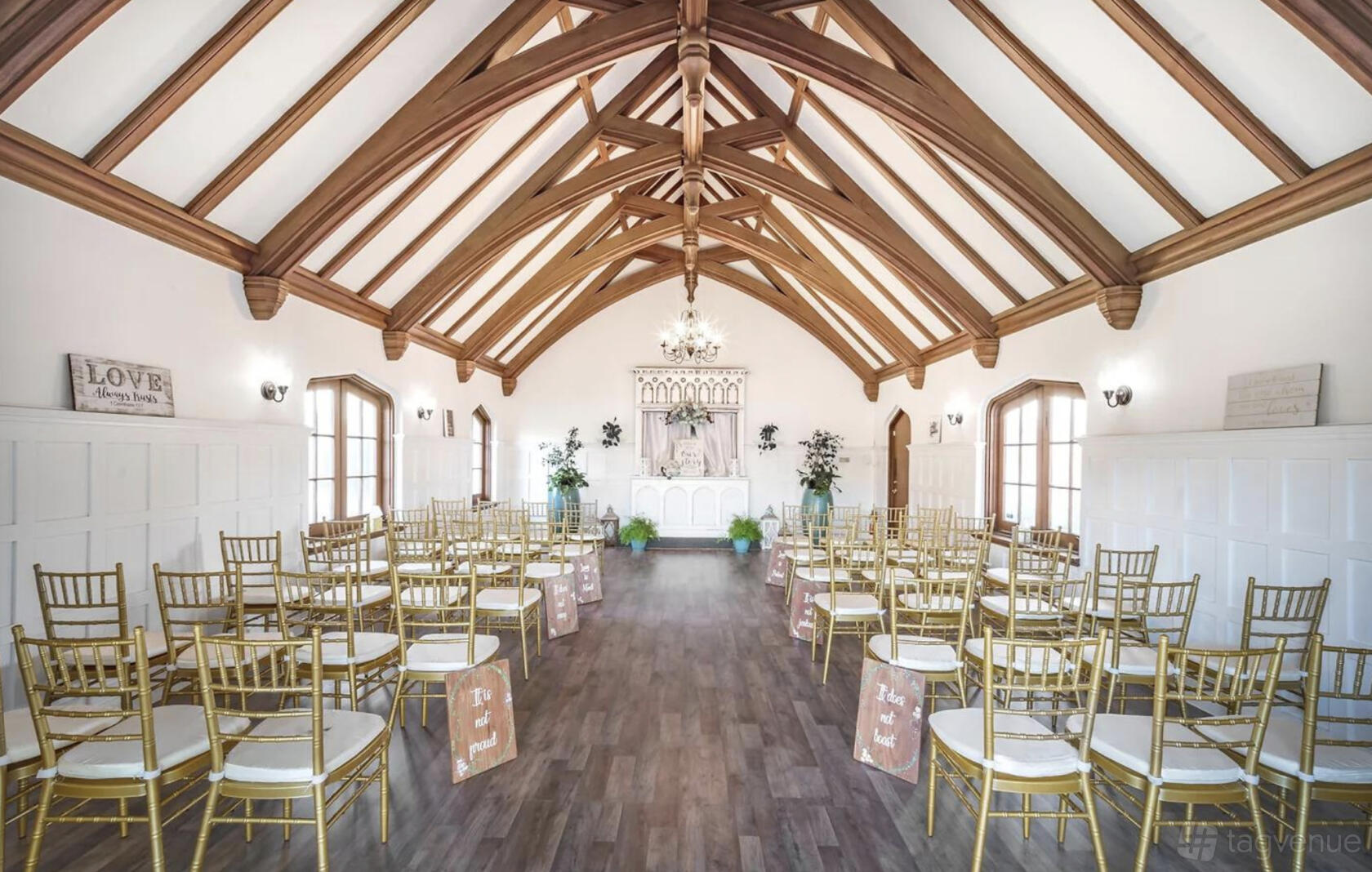 An event venue with vaulted wood beam ceilings, gold chairs, and an altar at Rose Creek Cottage 1900.