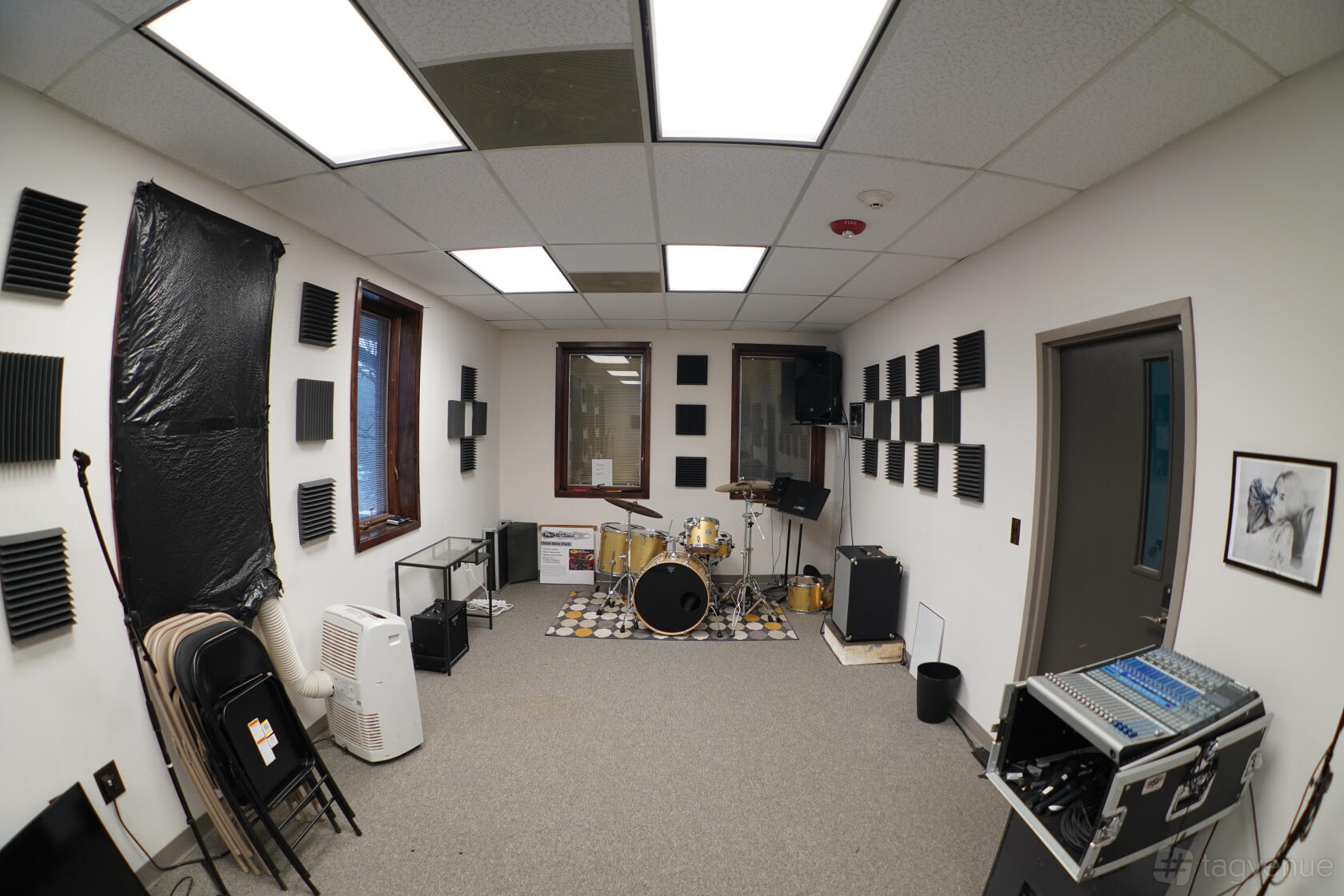 A rehearsal room with drum kit, soundproofing panels, and audio equipment at Rehearse Live.