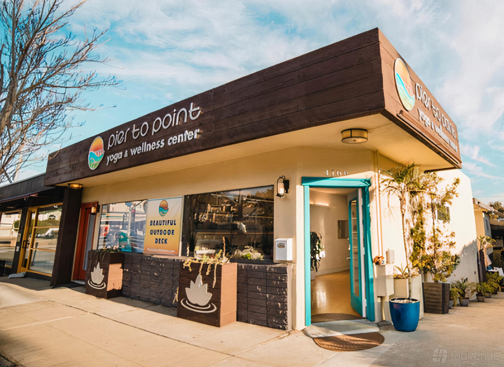 A dance studio with a brown wood facade, turquoise door, and large front windows at Pier To Point Yoga & Wellness Center.