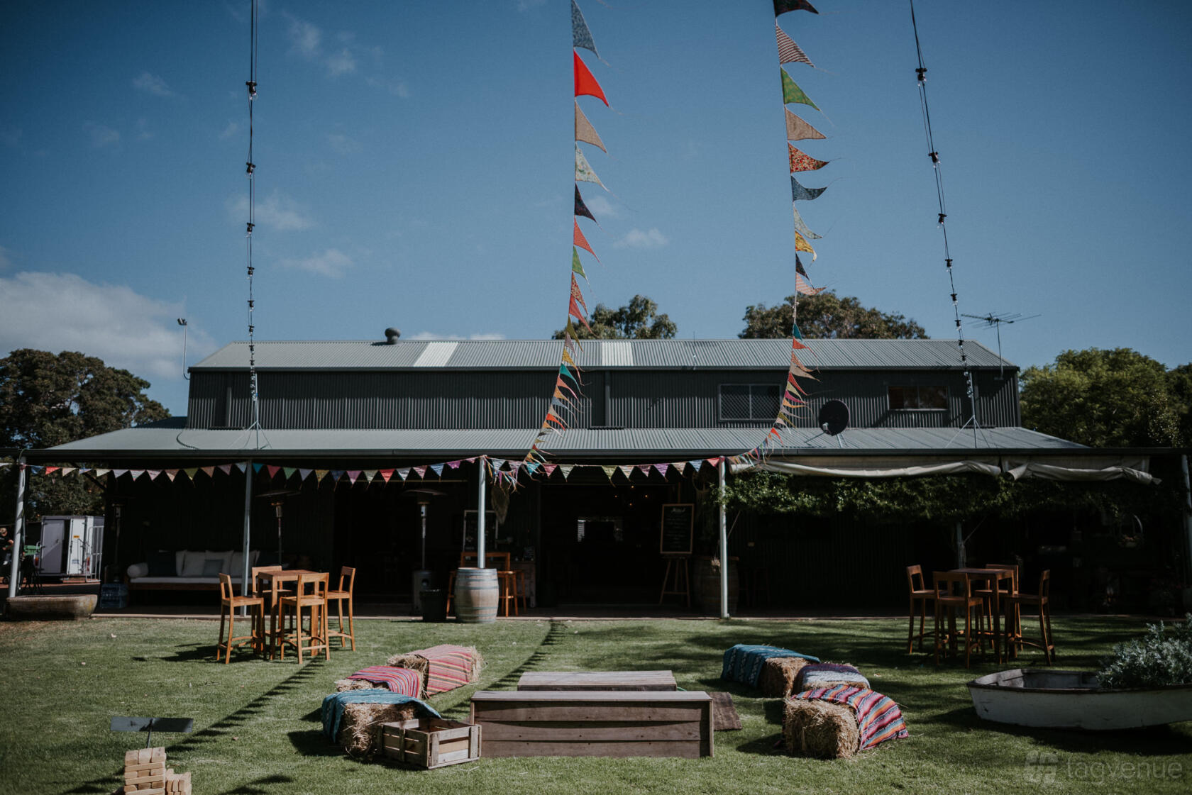 A barn venue with colorful bunting, outdoor seating on lawn, and rustic decor at Solitaire Homestead.