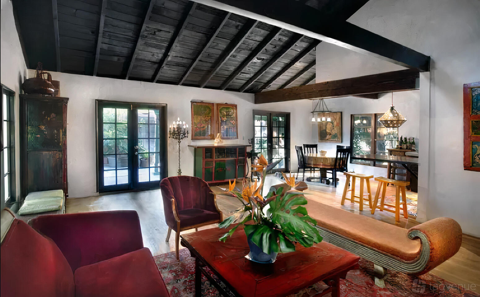 A house with exposed dark wood ceilings, large windows, and eclectic furnishings at Exotic House & Tropical Garden.