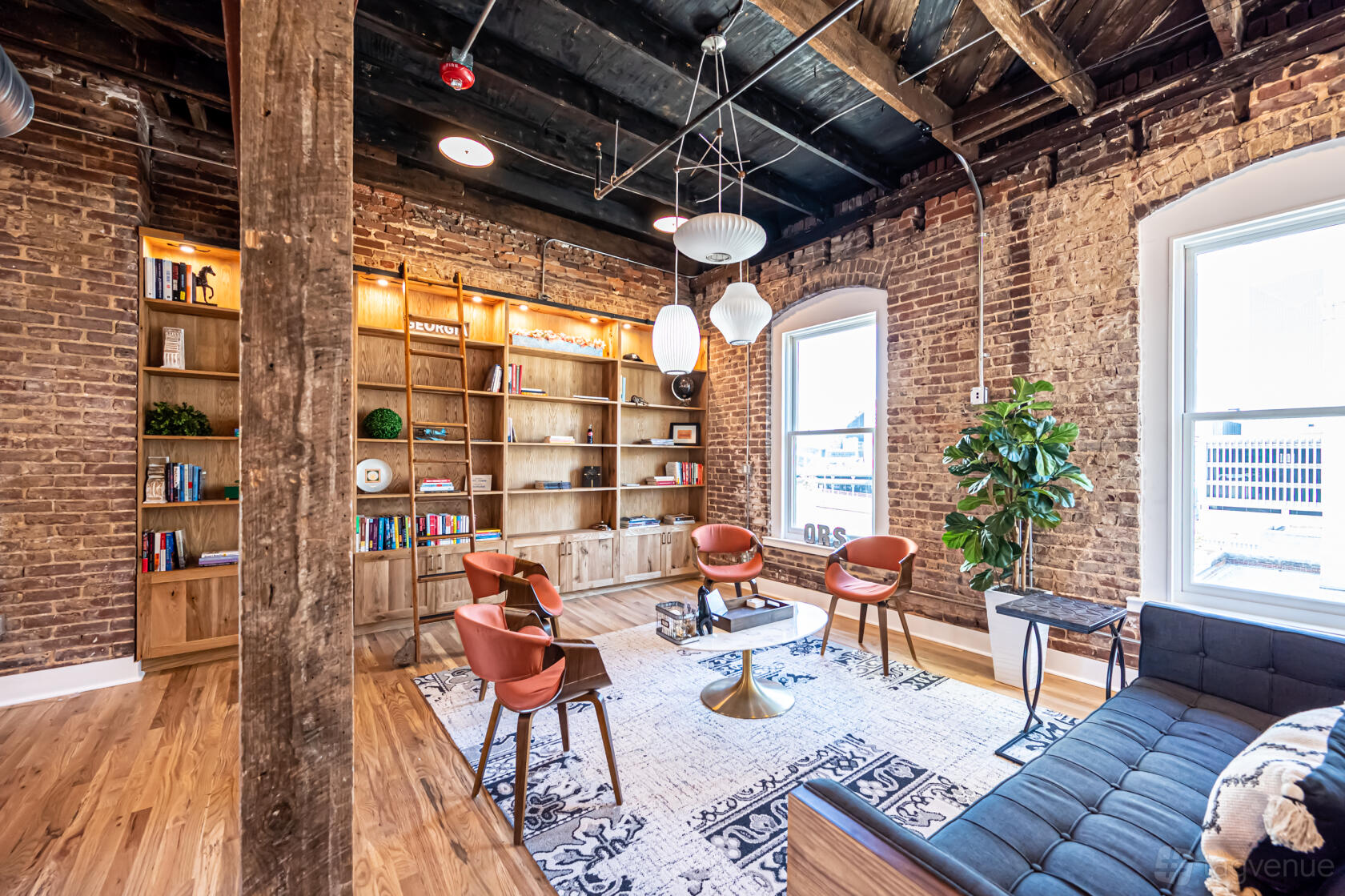 A meeting centre with exposed brick walls, wooden beams, and lounge seating at Ohio River South.