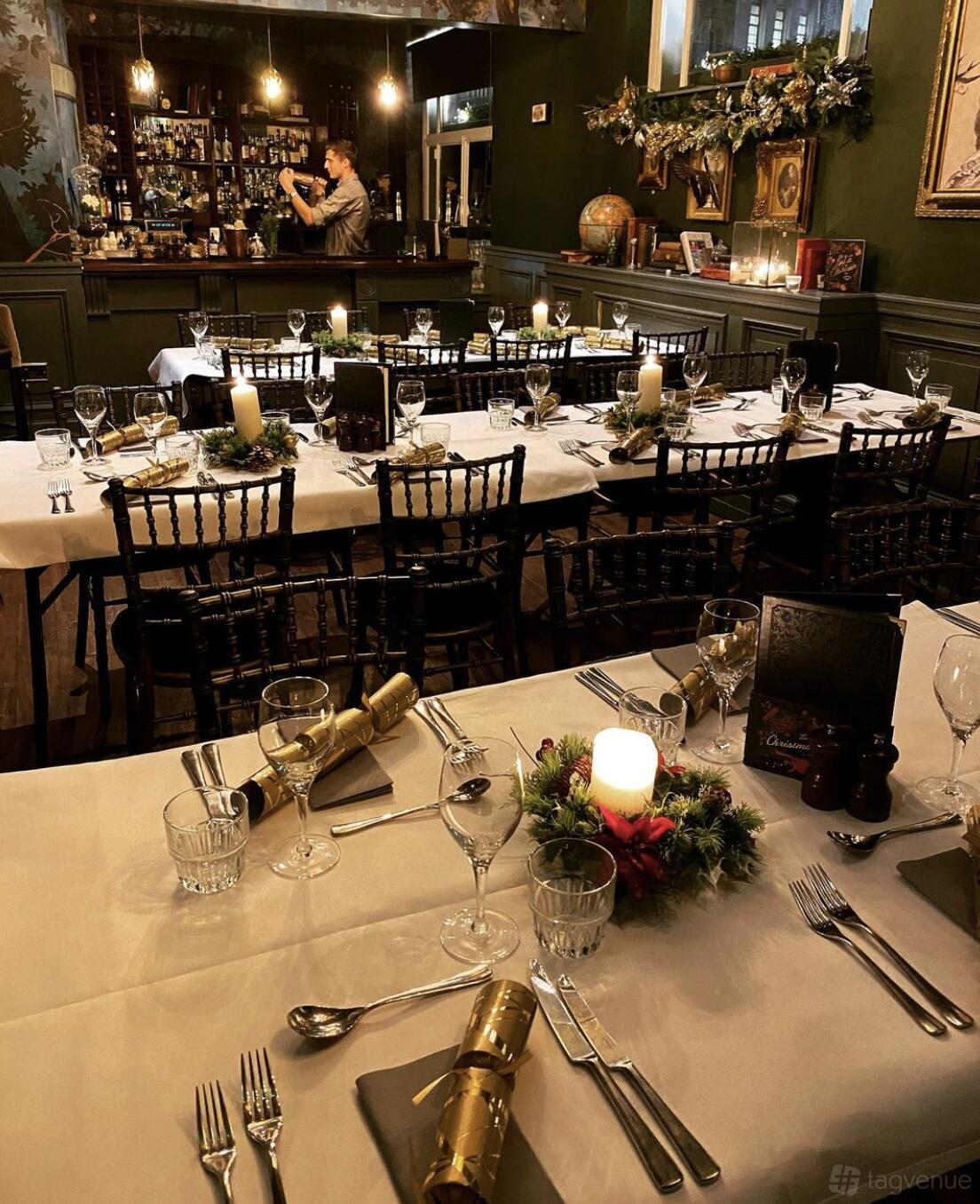 A function room with banquet tables set with candles, glassware, and festive decorations at The Lost & Found Birmingham.