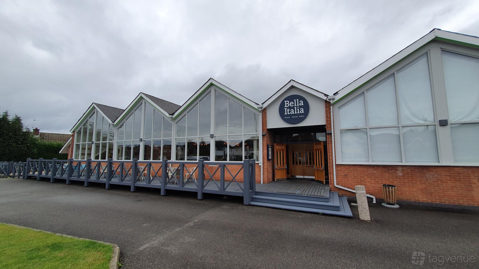 A hotel exterior with large windows, brick facade, and accessible ramp at Holiday Inn Leicester - Wigston.