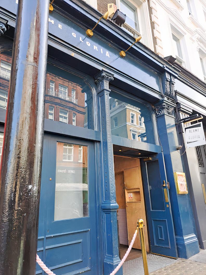A pub entrance with deep blue painted facade, large windows, and a Blame Gloria sign at Blame Gloria Covent Garden.