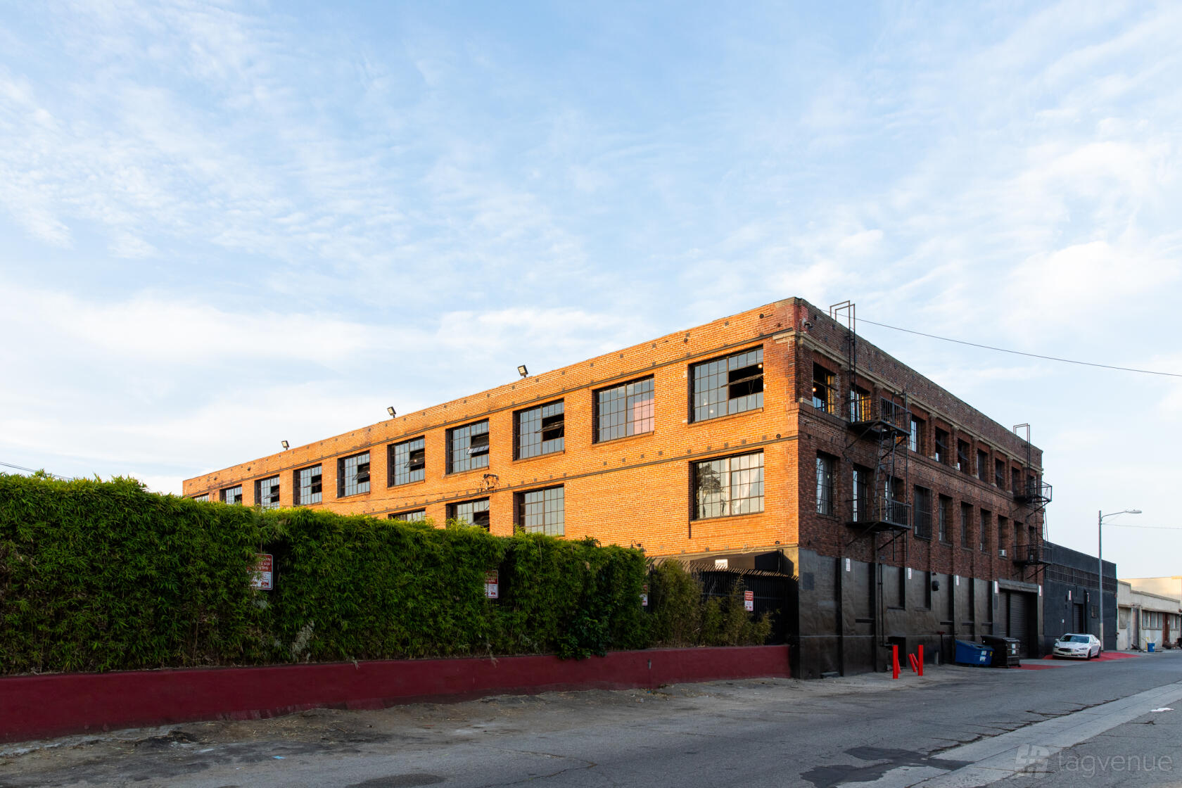 A warehouse with red brick exterior and large industrial windows at Versatile Warehouse Complex.
