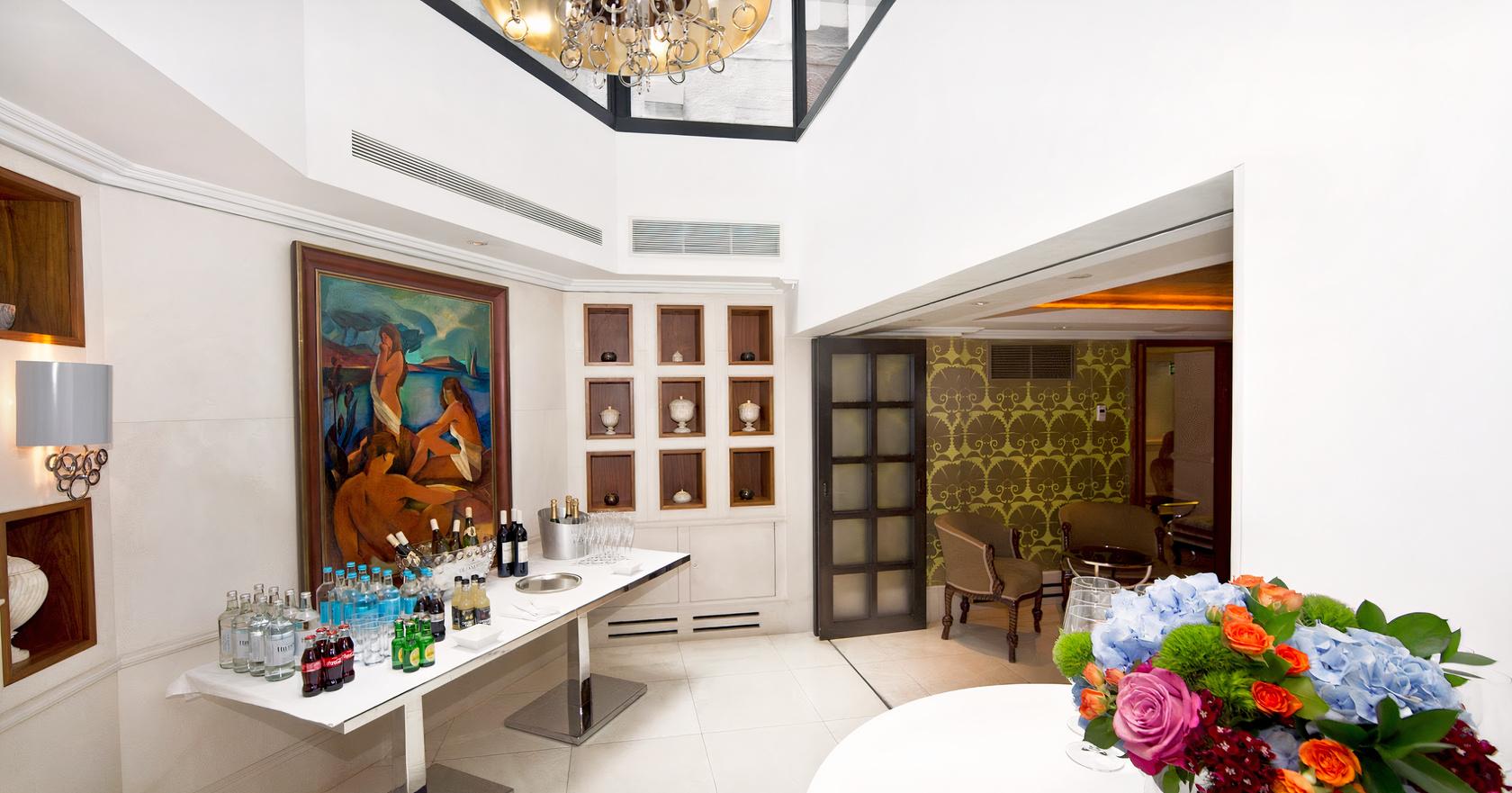 An event space with a drinks station, large painting, and a skylight at St James's Hotel and Club.