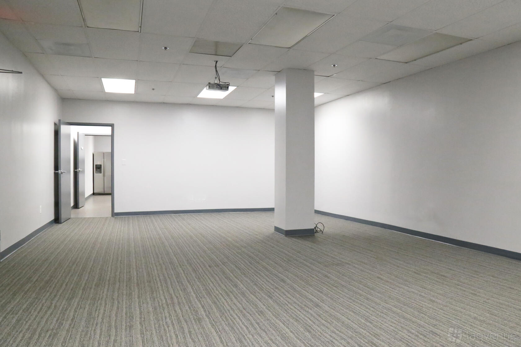 An event space with neutral walls, striped carpet flooring, and a ceiling-mounted projector at Perfect Office Solutions - Riverdale 6811.