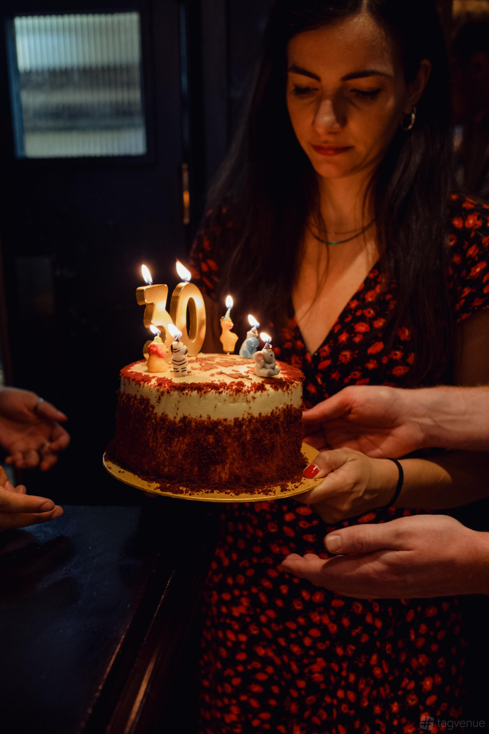 An underground cocktail bar with a 30th birthday cake decorated with animal candles at LOCKES Bar Covent Garden.
