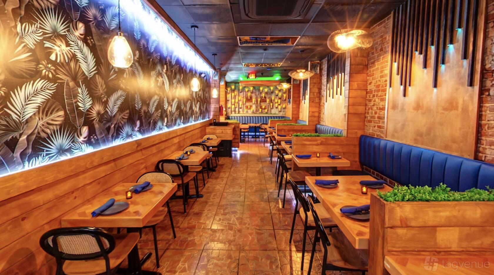 A restaurant dining room with wooden booths, patterned tile flooring, and leafy wall decor at Estrella Taqueria Lounge.