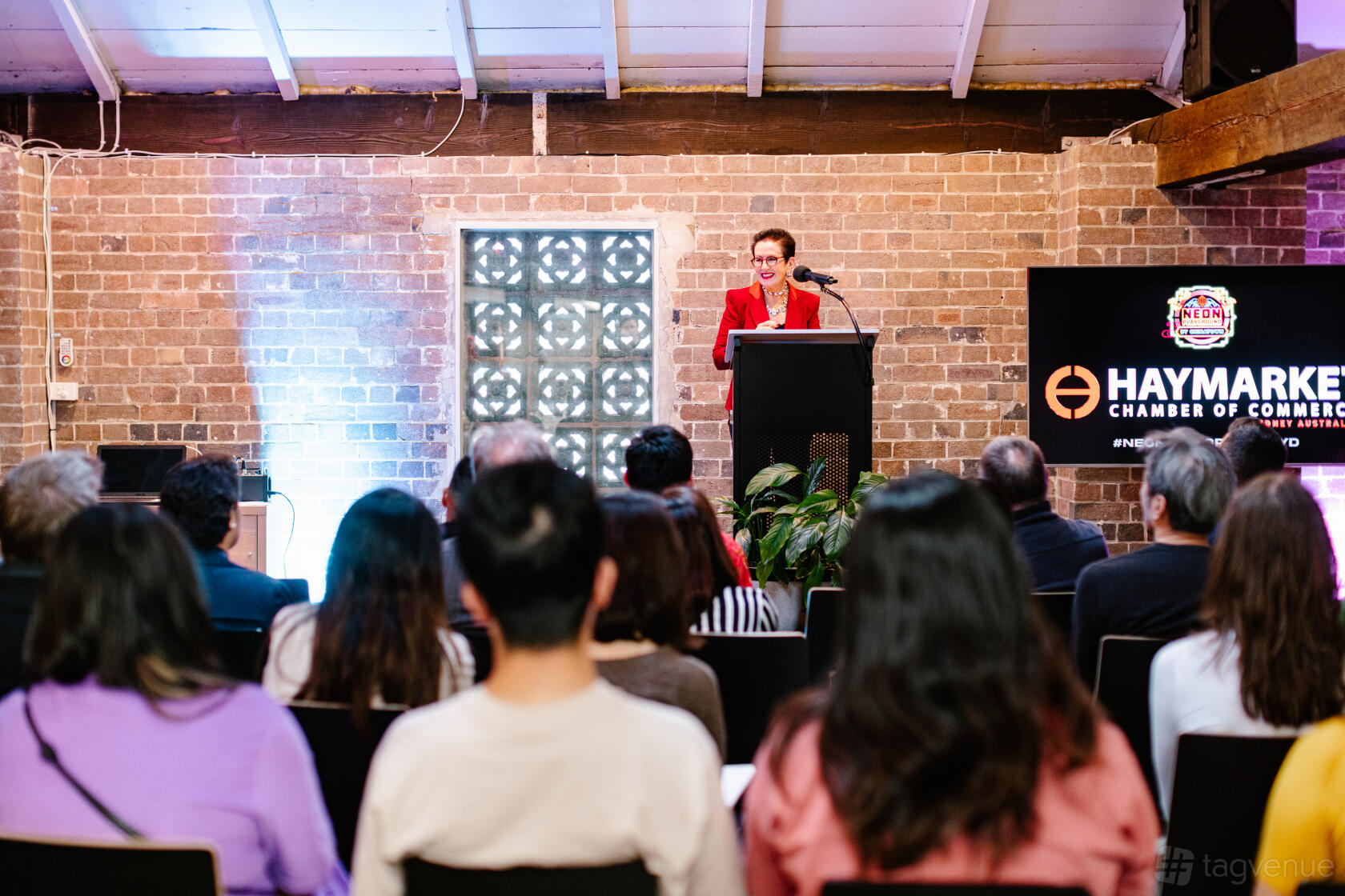 An event space with exposed brick walls, high ceilings, and a speaker podium at Haymarket HQ.