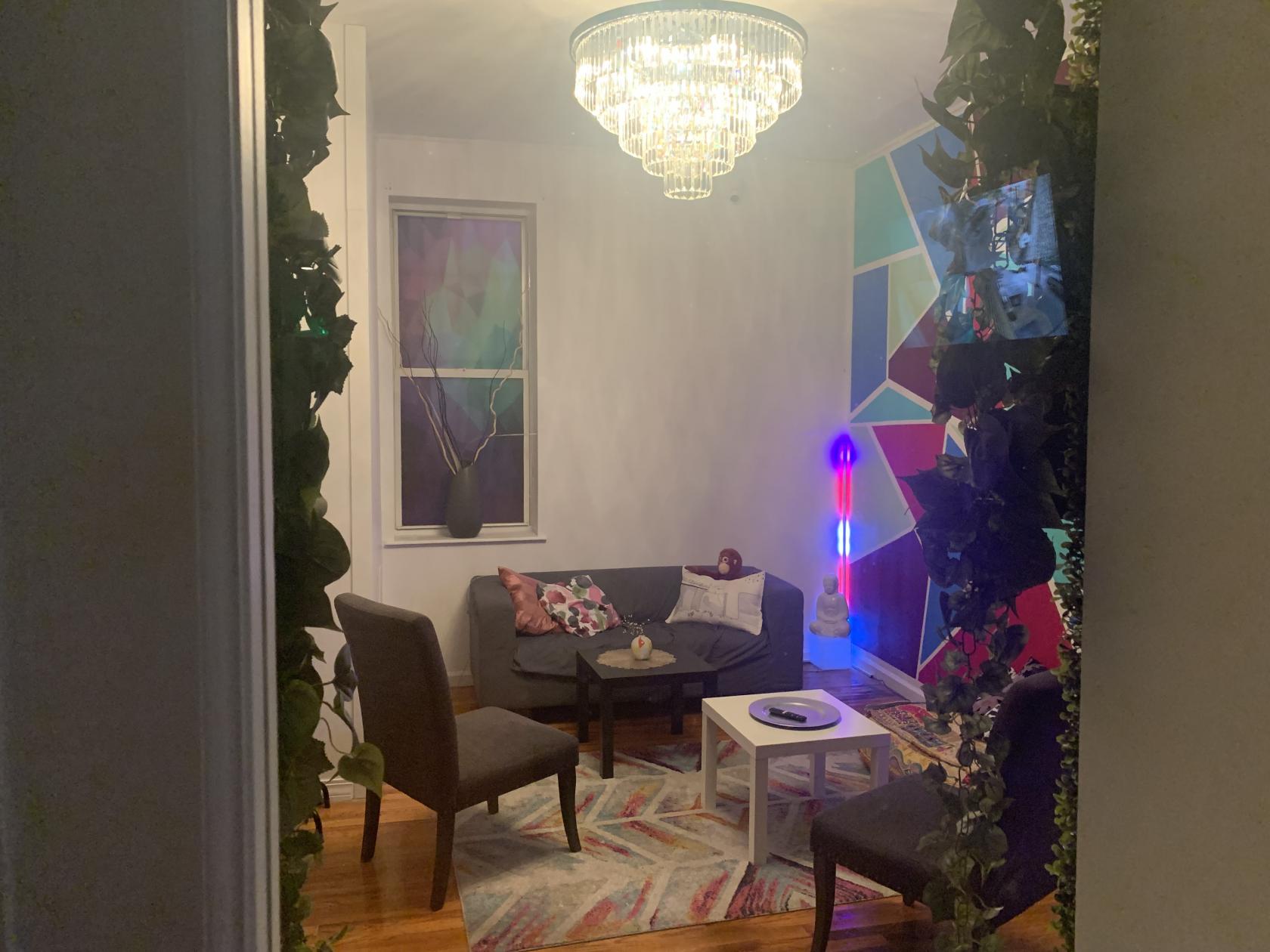 An event venue with geometric wall art, velvet seating, a chandelier, and a round table at H I D D E N.