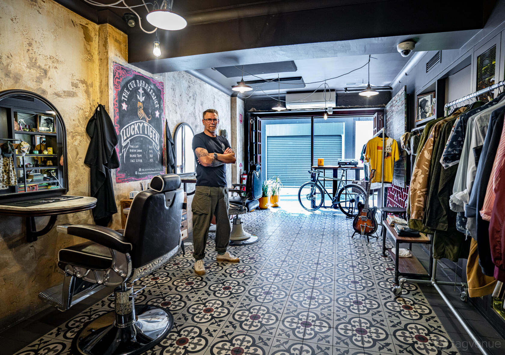 A pop up space in a restaurant with patterned tile floors, vintage barber chairs, and racks of clothing at Red Lantern Restaurant & Private Dining Room.