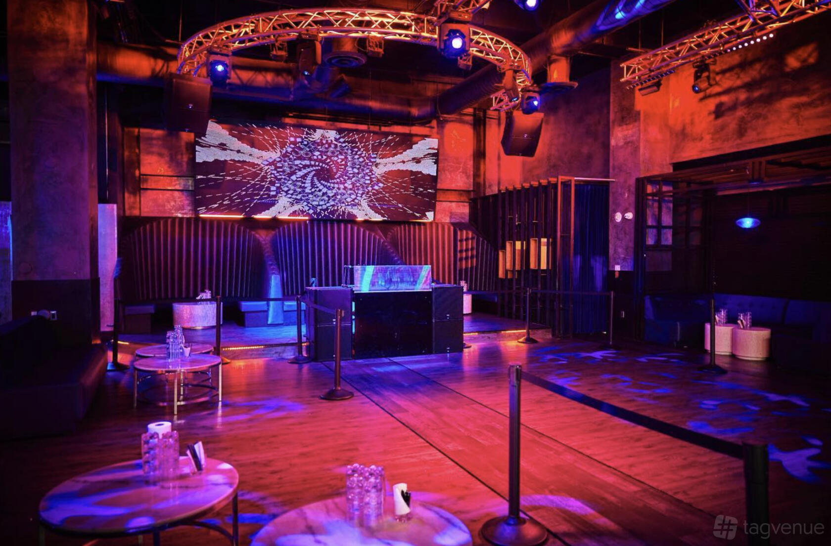 A nightclub with a central DJ booth, LED light projections, and lounge seating at Terracotta.