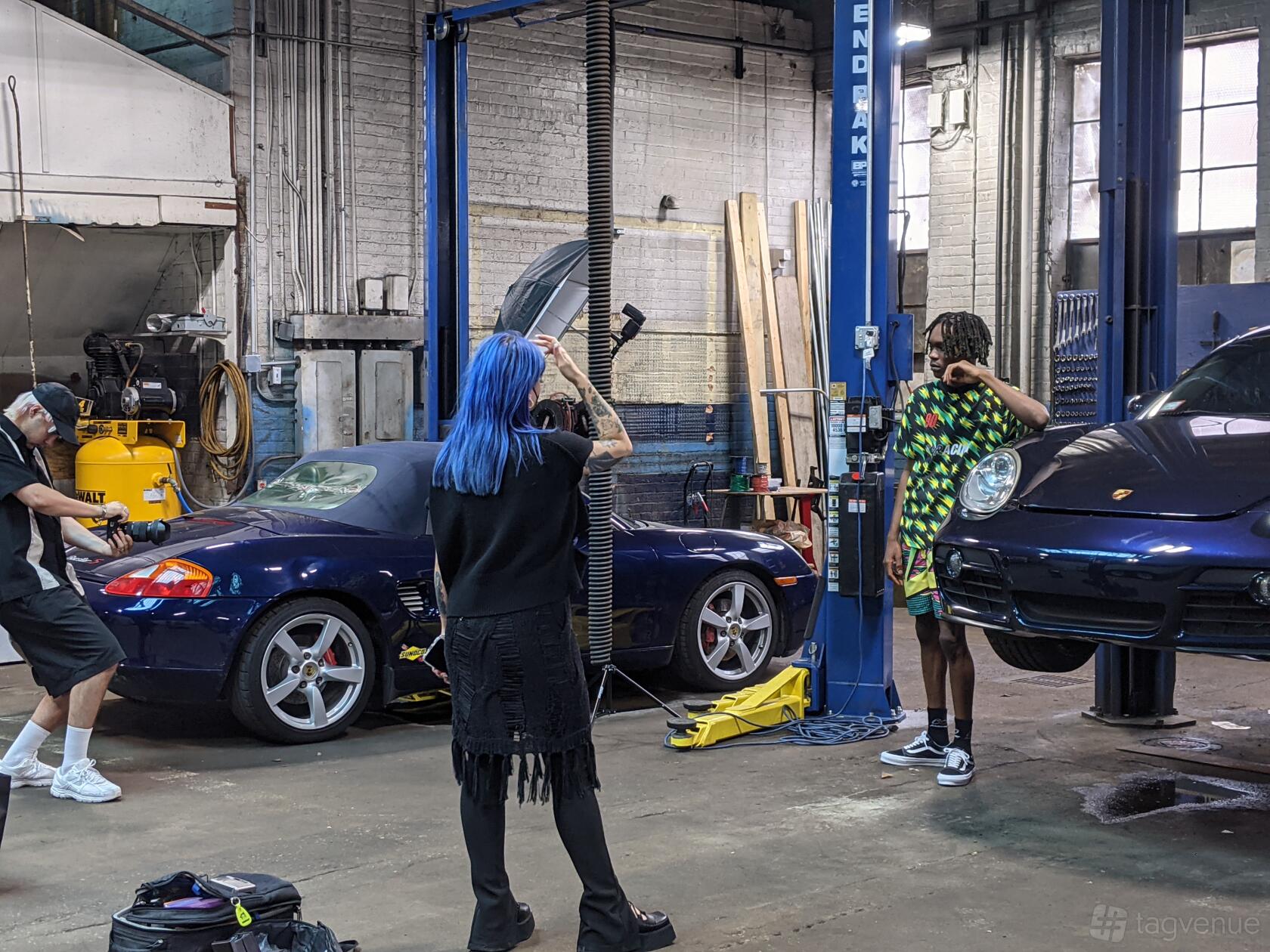 A warehouse with exposed brick walls, car lifts, and two sports cars at Gearhead Workspace.