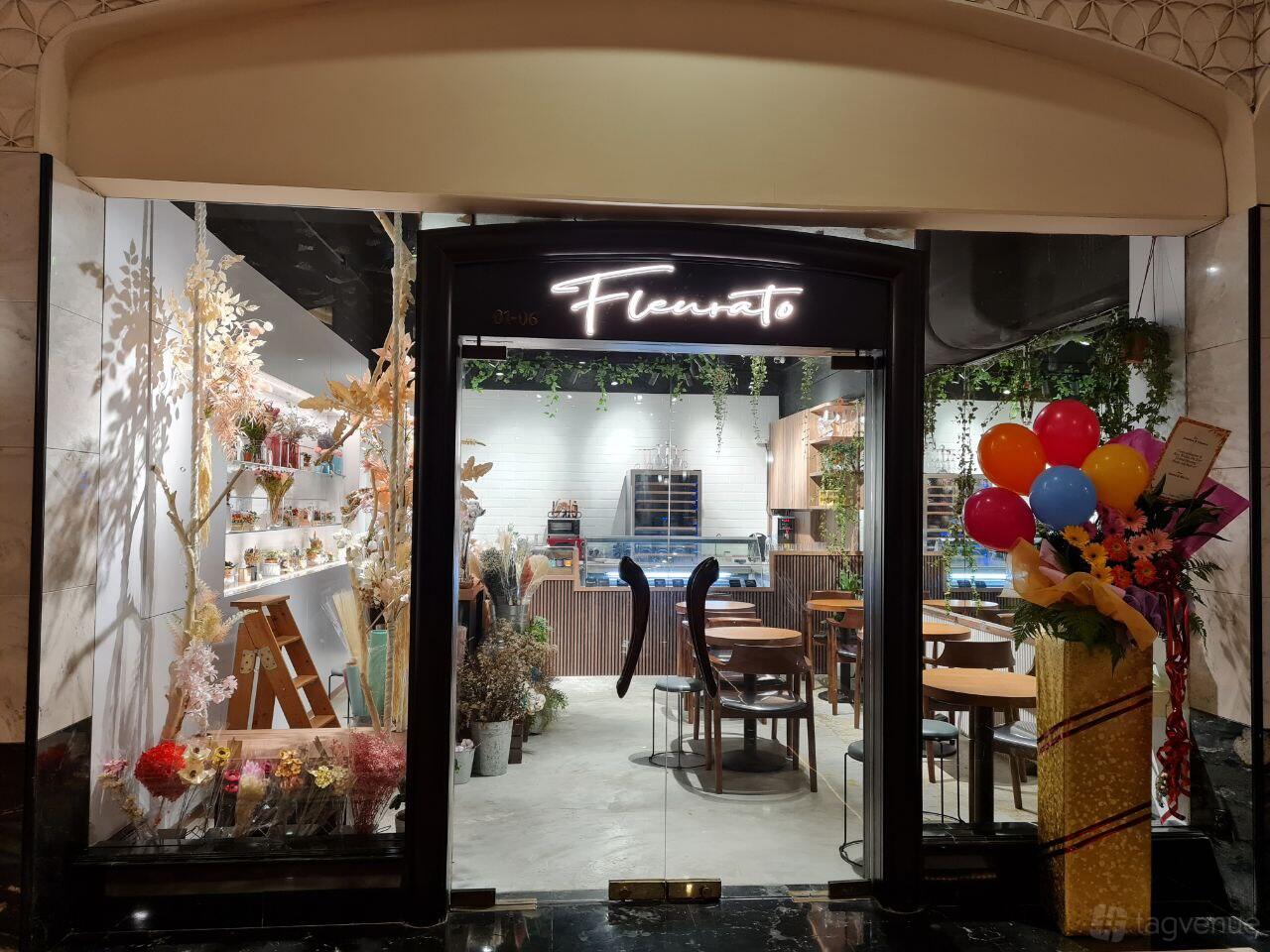 A versatile event space with floral arrangements, wooden tables, and greenery accents at Fleurato.