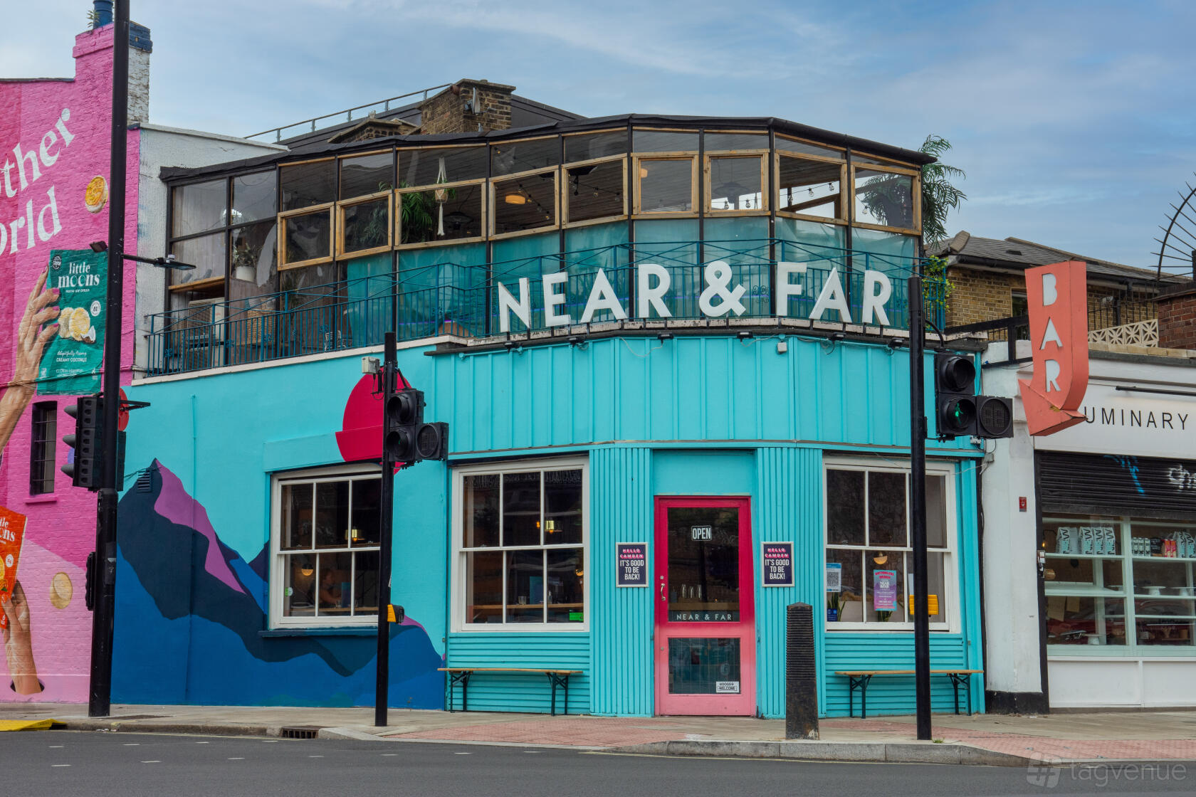 A versatile event space with a turquoise facade, large windows, and a glass-enclosed upper level at Studio48 Bar & Kitchen.