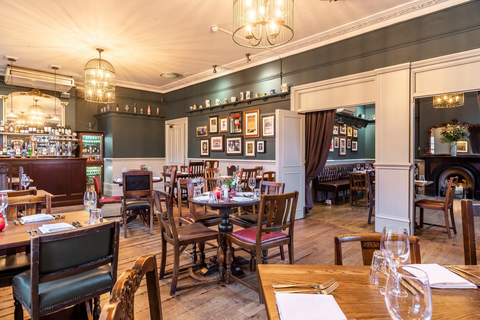 An event space in a pub with wooden floors, framed artwork, and a cozy dining setup at White Horse, Parsons Green.