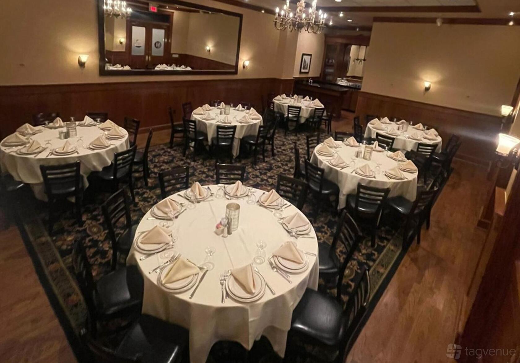 A dining room with round tables draped in white linens and neatly folded napkins at Maggiano's Little Italy Chevy Chase.