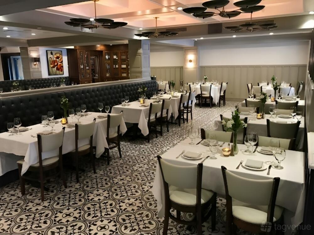 A restaurant dining area with patterned tile flooring, white tablecloths, and banquette seating at Harleys American Grille.