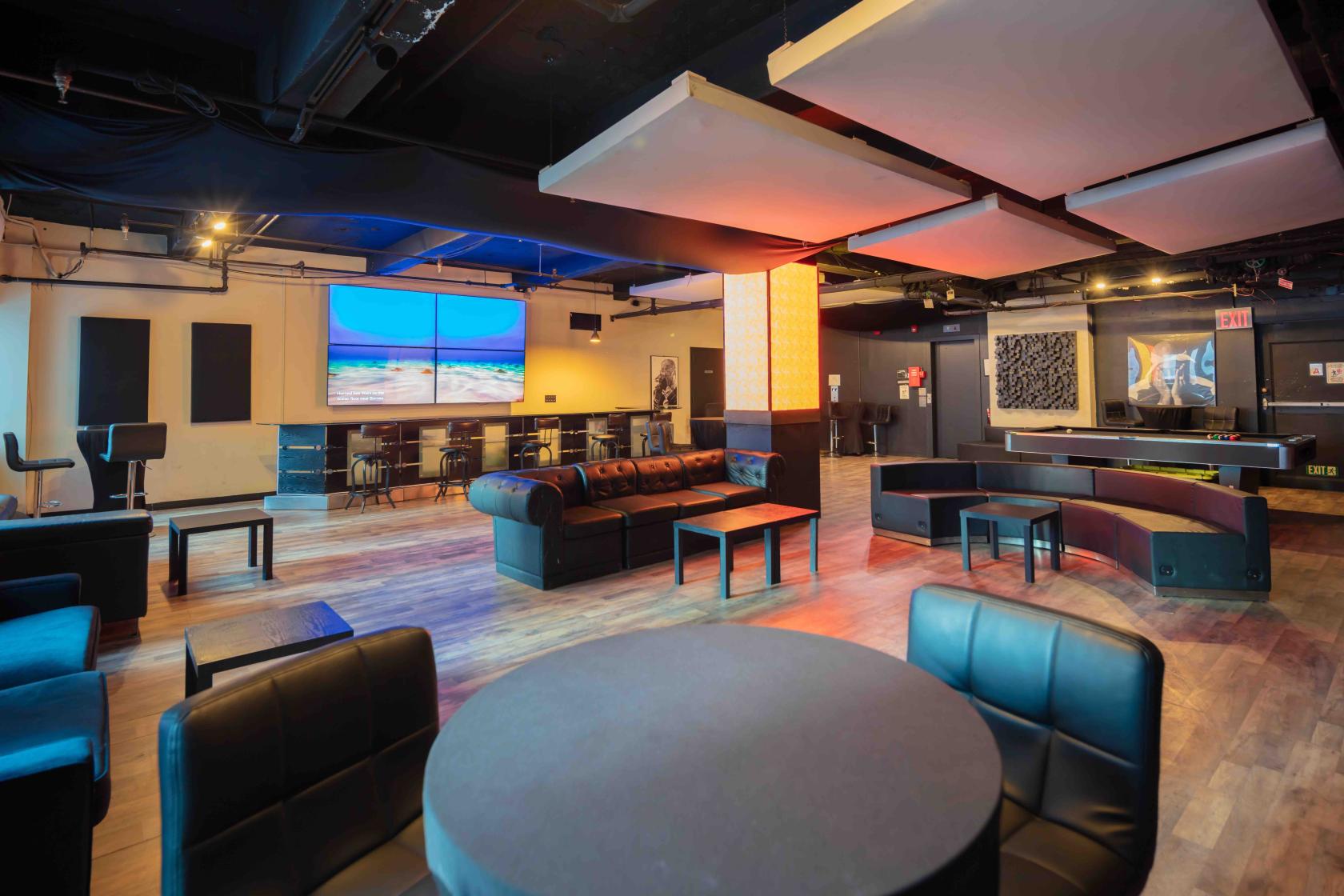An event space with wood floors, lounge seating, and ceiling acoustic panels at Quad Recording Studios.