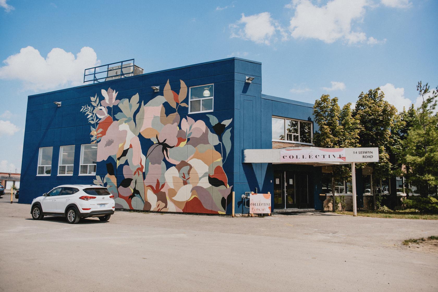 A meeting centre with a bold floral mural on a blue exterior and a sign reading Collective at The Collective Workspace.