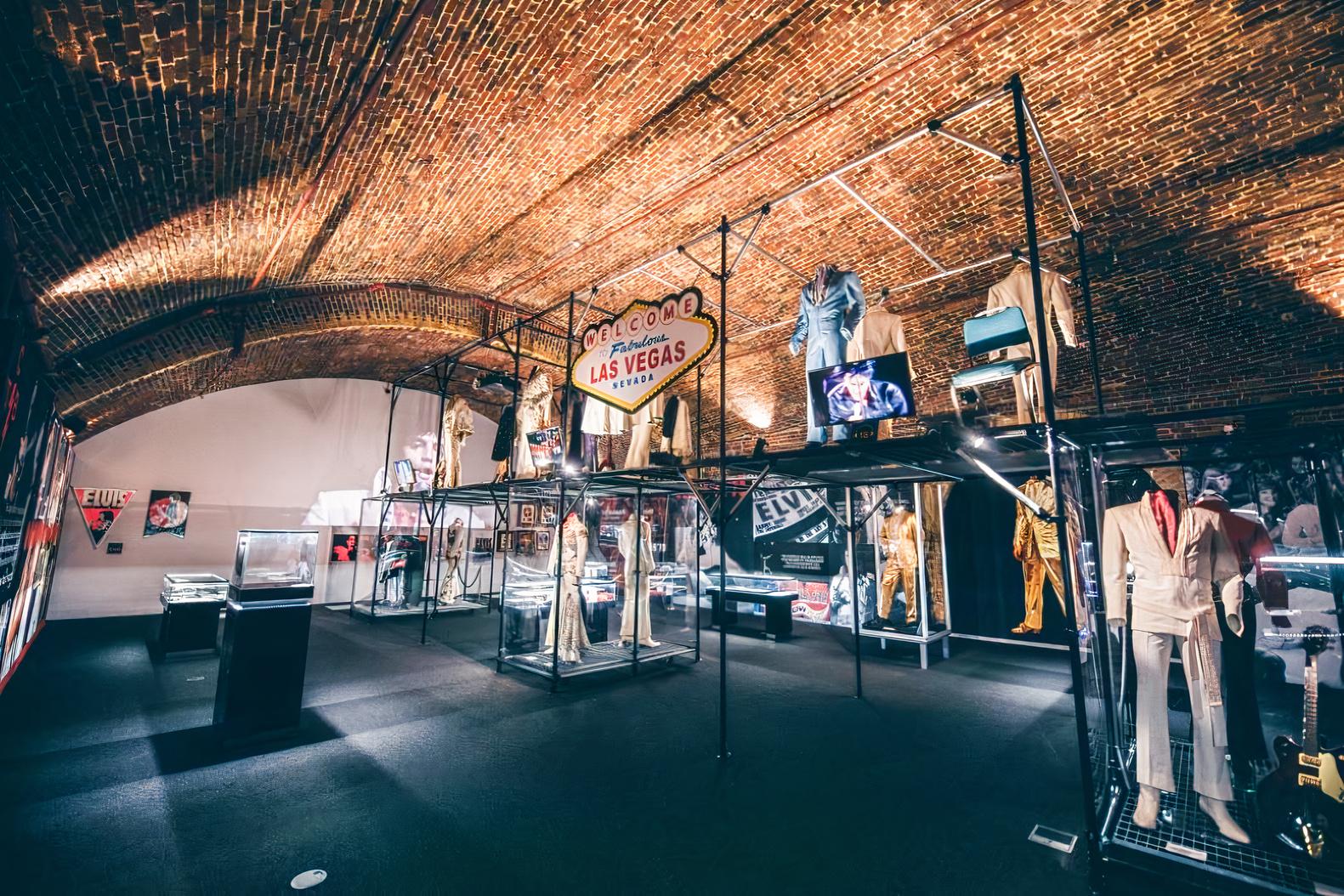 An event venue with vaulted brick ceilings, black carpet, and exhibition displays at Arches at London Bridge.