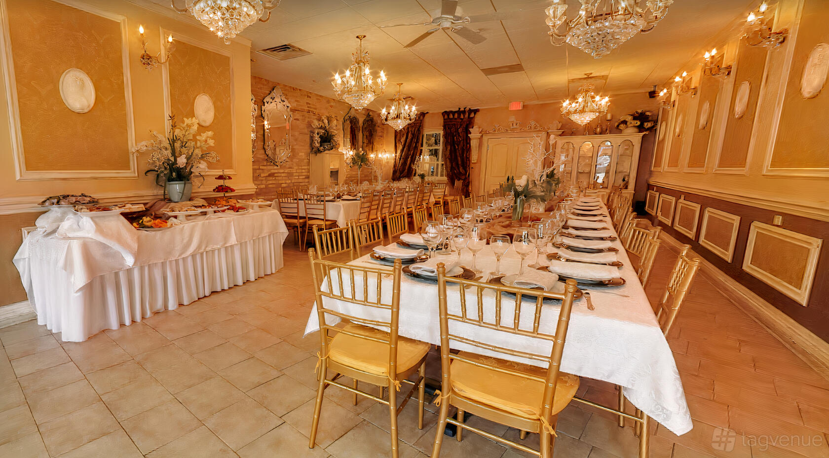 A dining room with two long banquet tables, gold chairs, chandeliers, and buffet setup at Staropolska Restaurant.