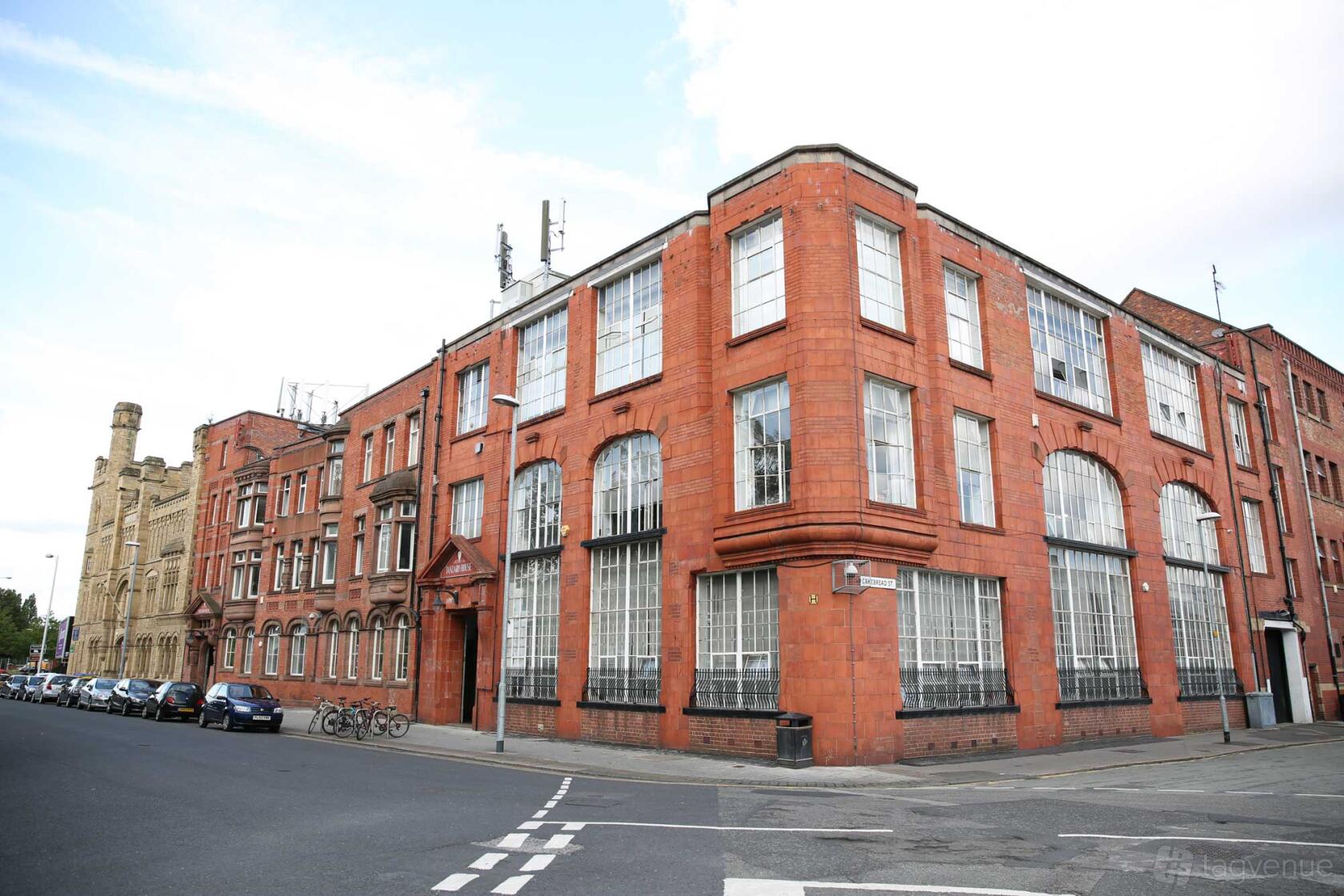 A film and photo studio with large industrial windows and a red brick facade at Tanzaro Photography Studio.