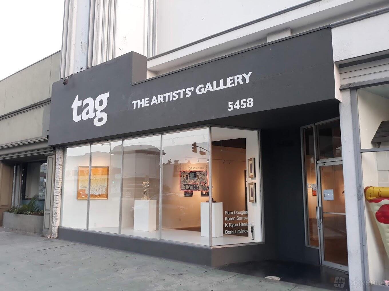 A gallery with large front windows displaying framed artworks and sculptures at TAG Gallery.