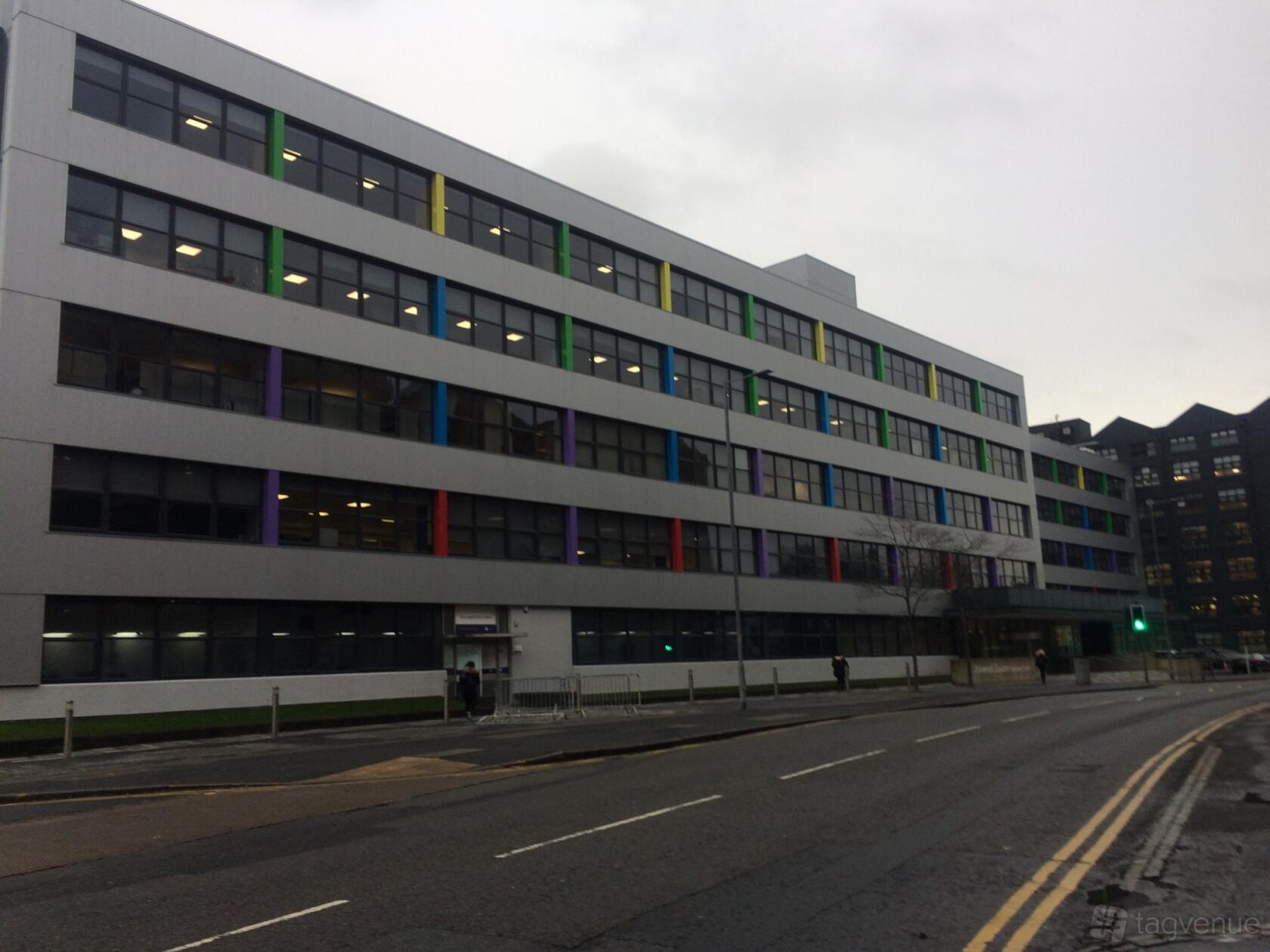 A meeting centre with a multi-story facade featuring colorful window accents and large glass panes at ITTS.