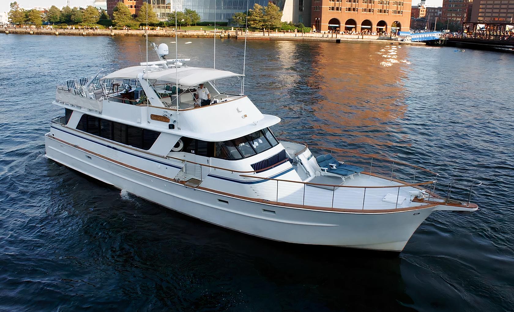 A white yacht with a spacious deck and outdoor seating cruising on the water at Lots Of Yachts/Lots Of Spots - New York.
