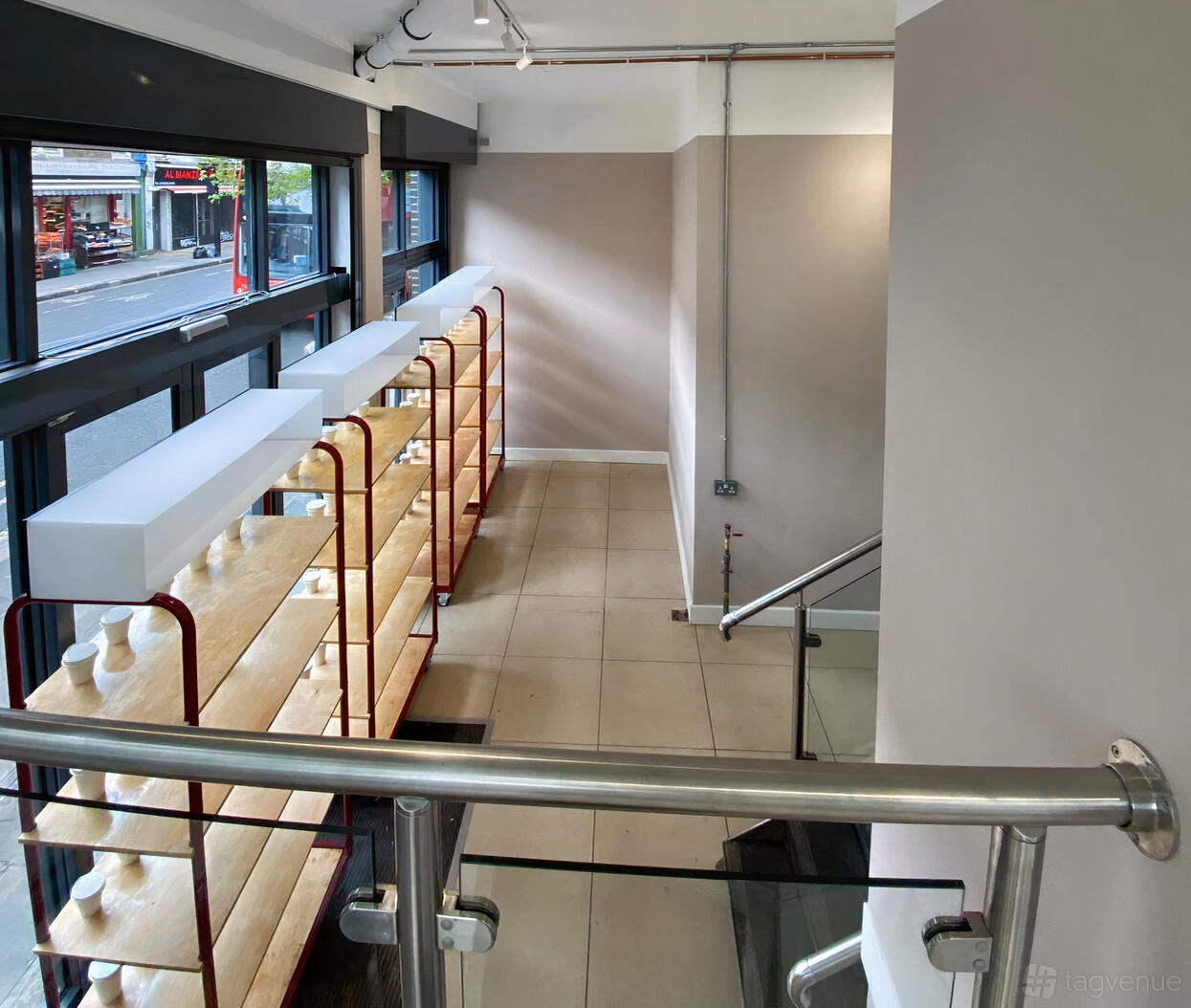 An event space in a cafe with floor-to-ceiling windows, open shelving, and tiled flooring at W10 Coffee + Deli.