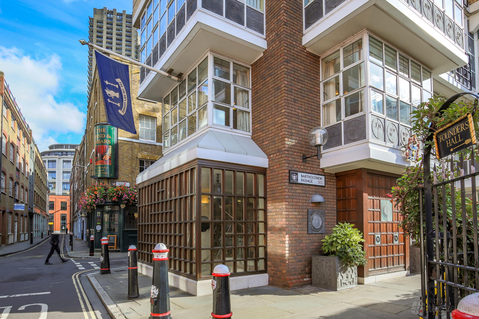 An entrance to a hall with large paned windows, brick walls, and street signage at Founders' Hall.