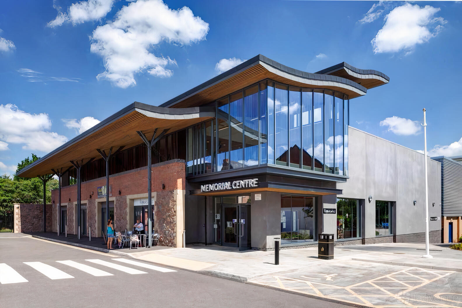 A versatile event space with floor-to-ceiling windows, a wood-accented roof, and a glass entrance at MMC Venue - Mountsorrel Memorial Centre.