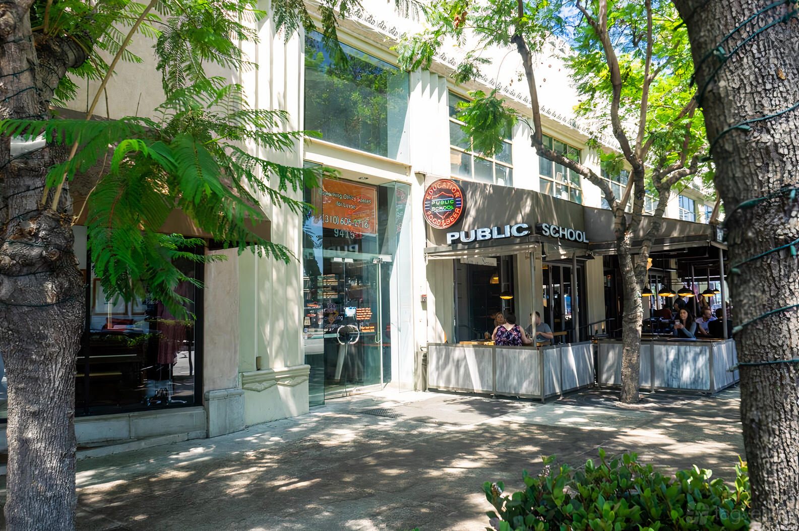 A coworking space with large glass windows and shaded sidewalk outside BLANKSPACES Culver City.