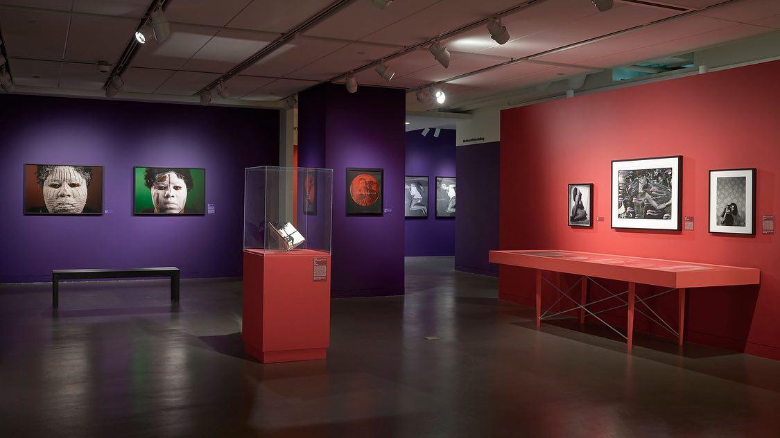 An event space in a museum with colorful walls, framed artwork, and display cases at Museum of The African Diaspora.