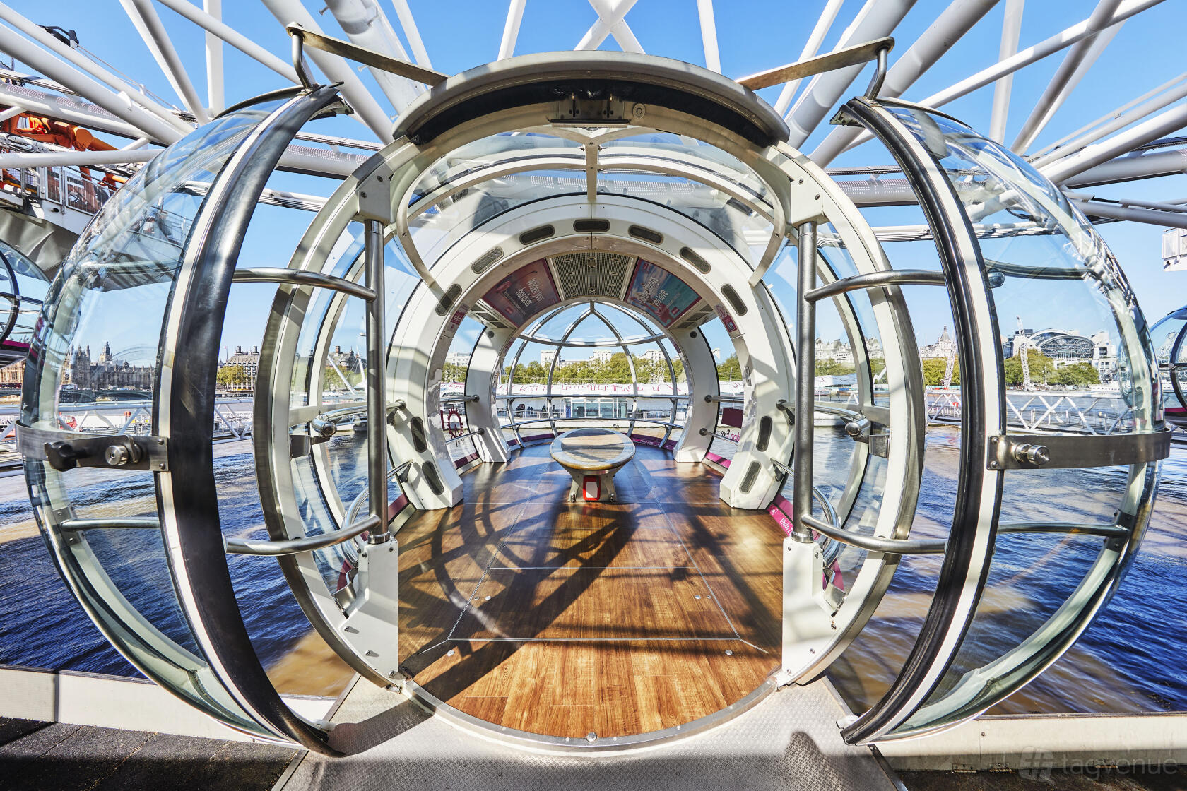 An event venue with a glass-enclosed pod featuring wooden floors and panoramic city views at London Eye.